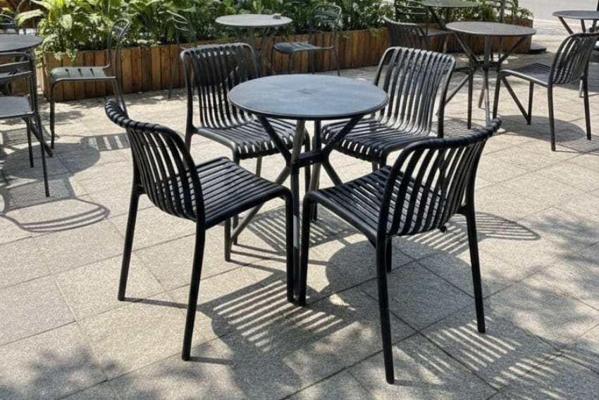 Ghế nhựa dựa lưng kết hợp với bàn ở quán cà phê ngoài trời